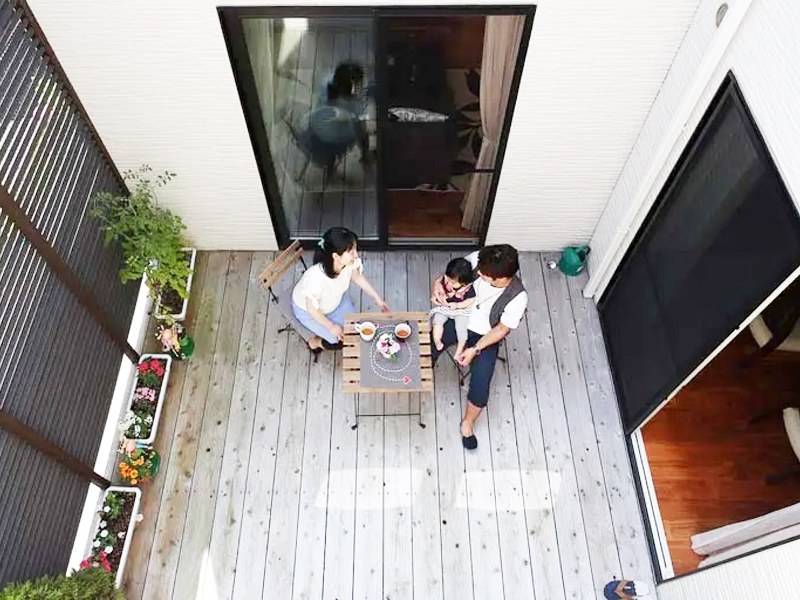 平屋の中庭で寛ぐ家族の写真