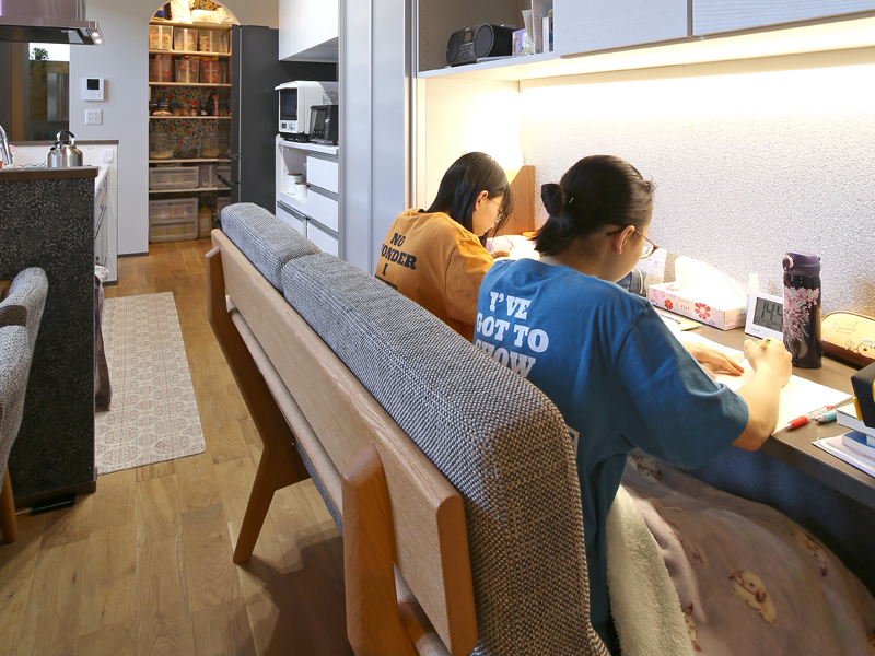 1階のキッチン横カウンターで勉強する子供たちの写真